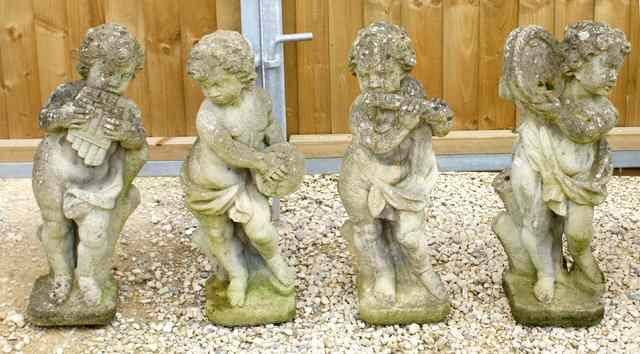 Appraisal: A GROUP OF FOUR RECONSTITUTED STONE PUTTI each playing a