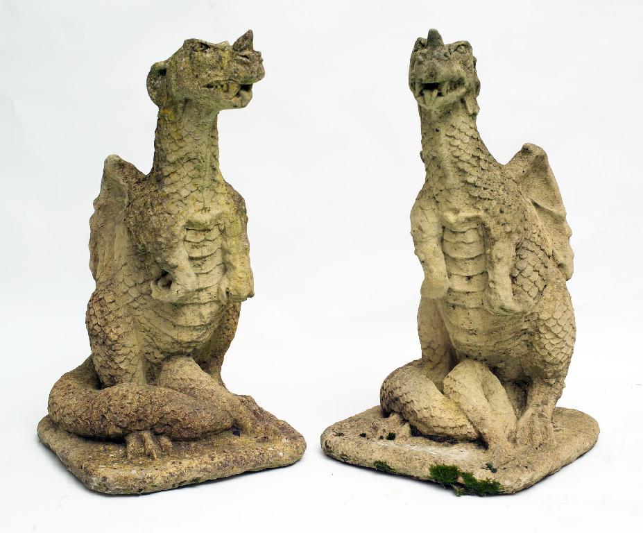 Appraisal: PAIR OF WEATHERED COMPOSITION STONE MODELS OF SEATED GRIFFINS each