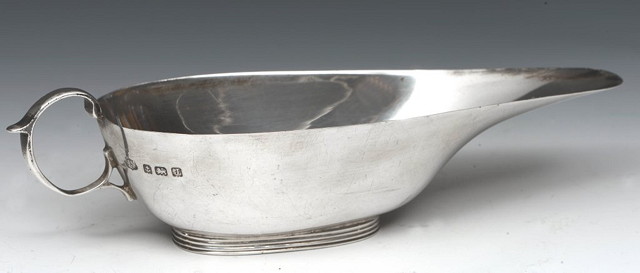 Appraisal: A SILVER BUTTER BOAT of shaped form with loop handle