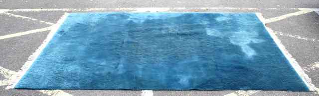 Appraisal: A PLAIN BLUE WOOLLEN CARPET with fringed ends approximately ft