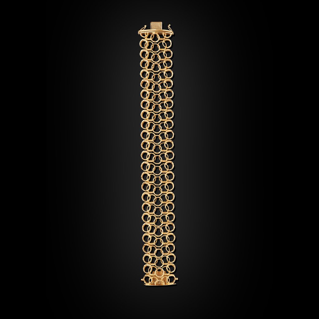 Appraisal: A contemporary gold braceletcomposed of a broad design of textured