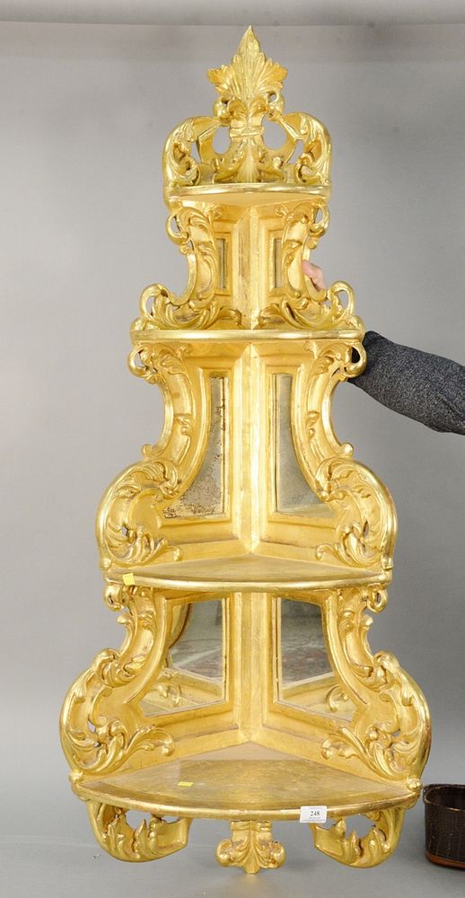 Appraisal: Gilded hanging corner shelf having four tiers and a mirrored