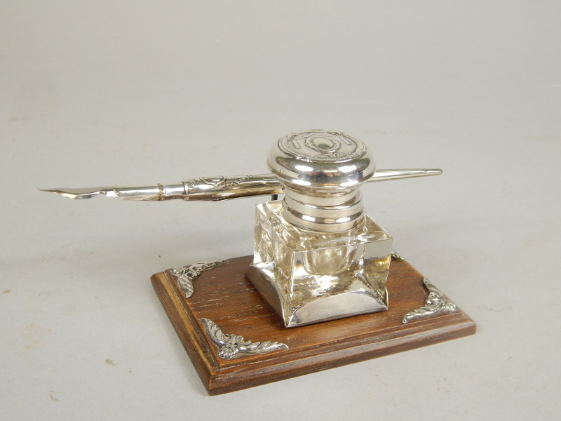 Appraisal: An inkstand and pen quill set on rectangular oak base