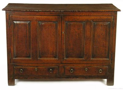 Appraisal: An oak cupboard the boarded moulded edge top above a