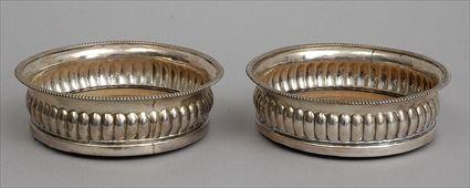 Appraisal: PAIR OF GEORGE III ARMORIAL SILVER BOTTLE COASTERS John Roberts