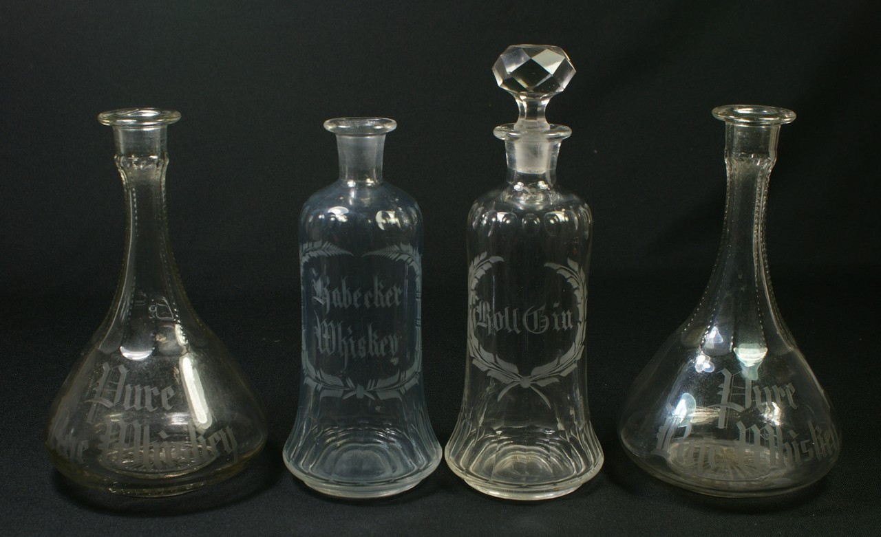 Appraisal: clear glass back bar bottles with etched decoration ROLL GIN