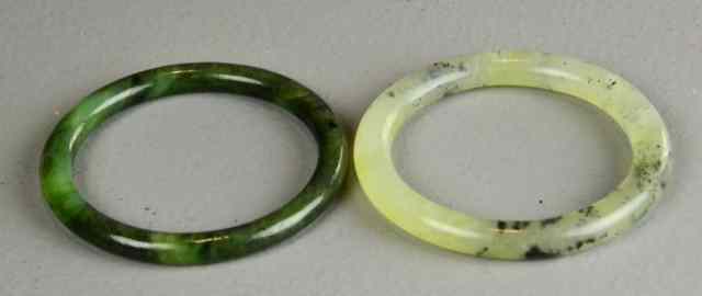 Appraisal: Chinese Jade BanglesTo include a light celadon example with black