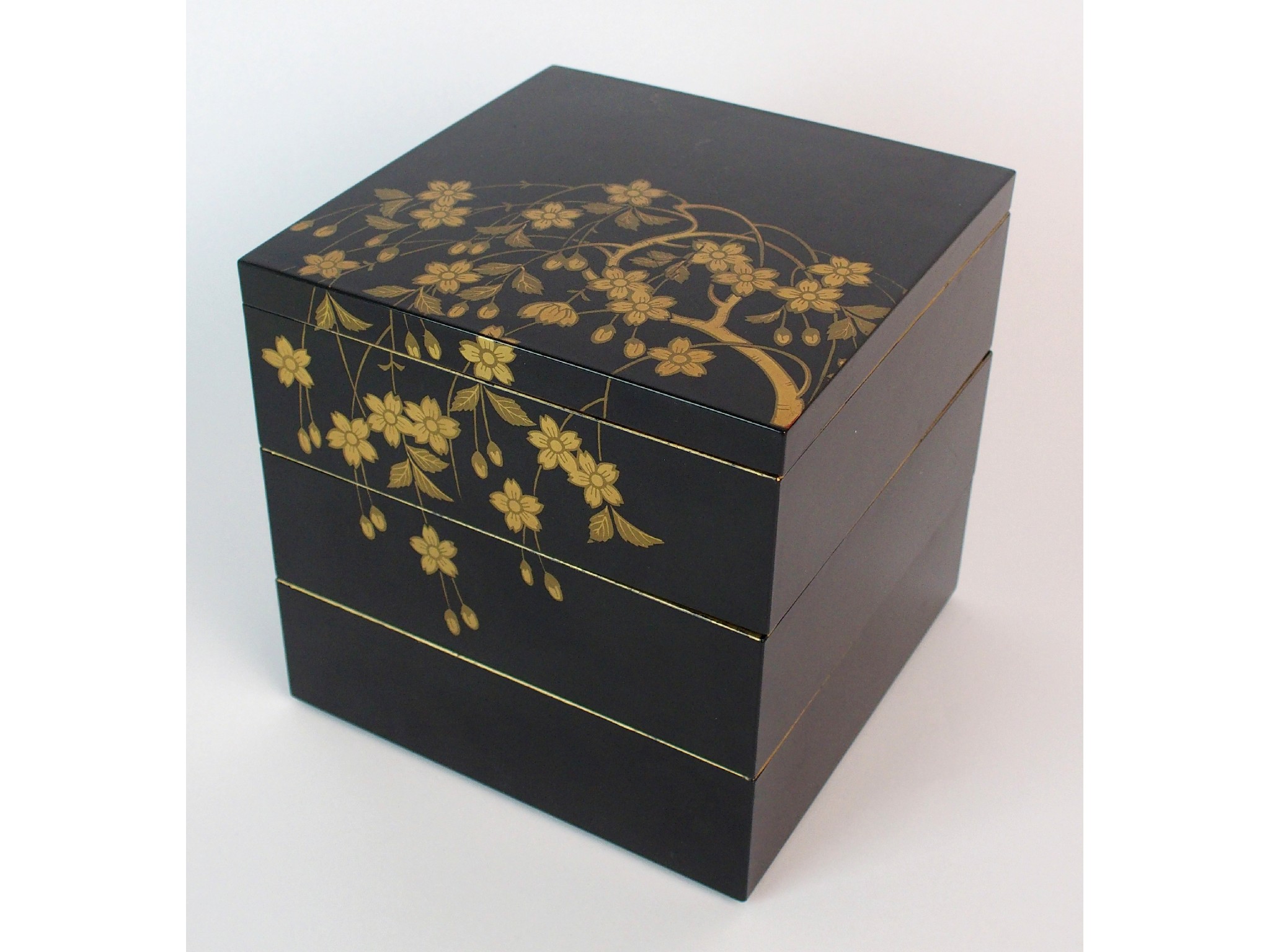 Appraisal: A Japanese black and gold lacquered square three tier box