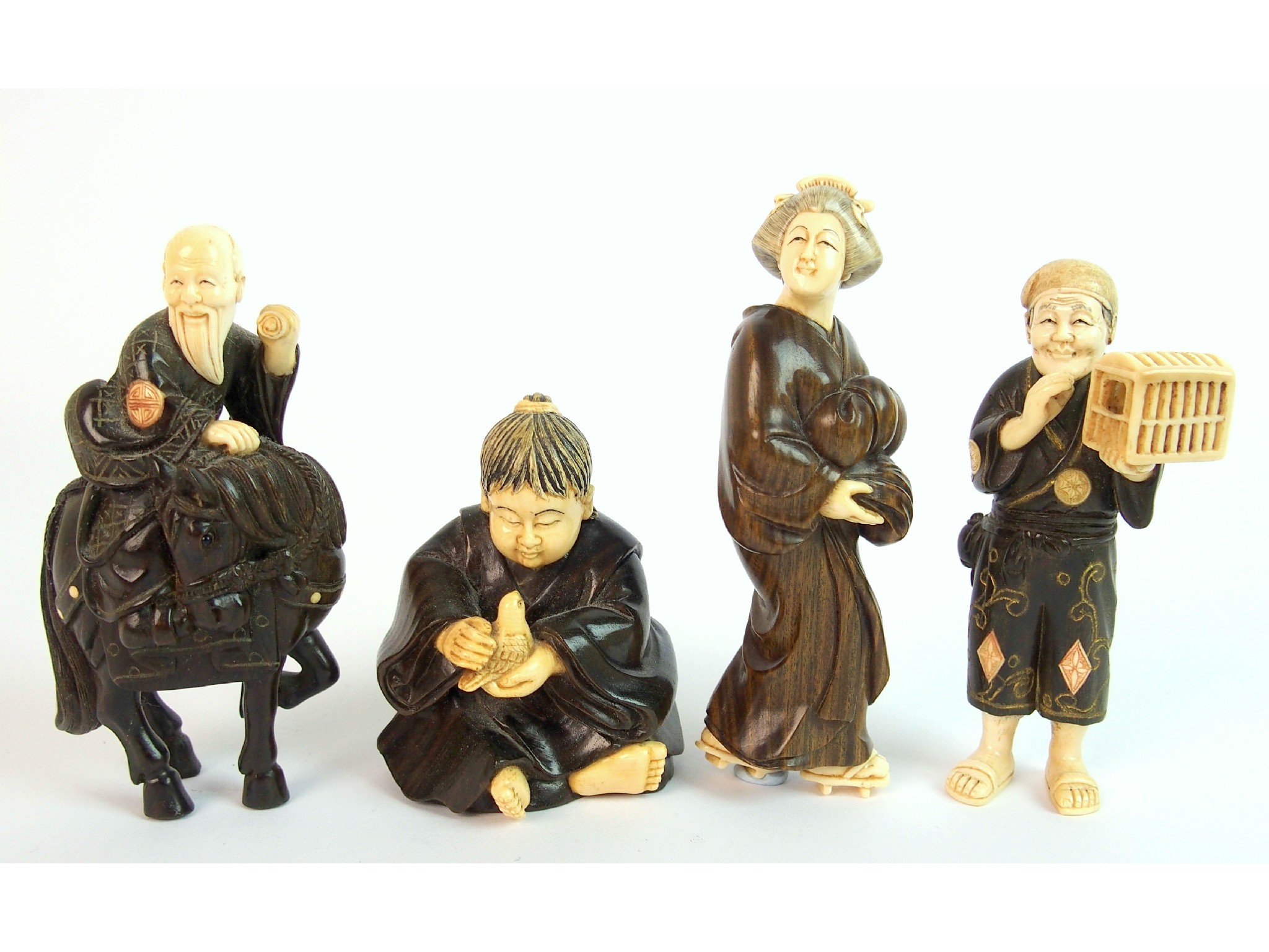 Appraisal: Four hardwood and ivory carvings comprising a lady cm high