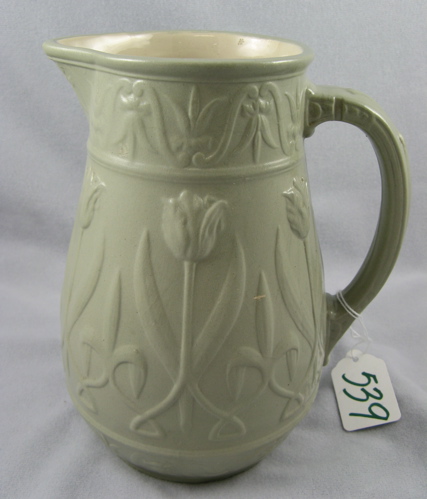 Appraisal: A GERMAN METTLACH STONEWARE PITCHER glazed in a pale green