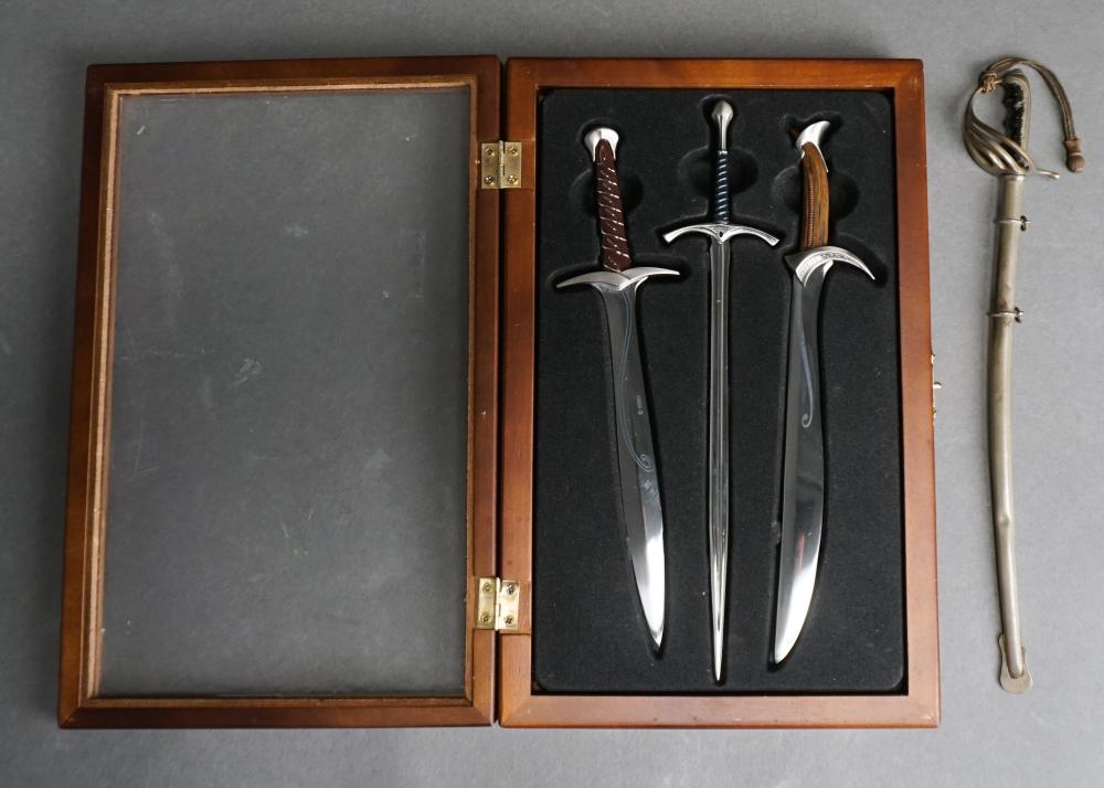 Appraisal: THREE LORD OF THE RINGS MINIATURE SWORDS ENCASED AND A