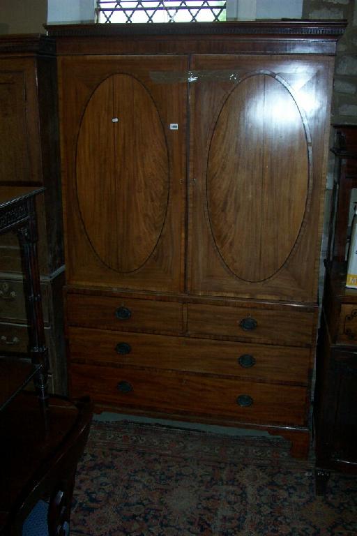 Appraisal: A Georgian mahogany linen press the upper section enclosed by