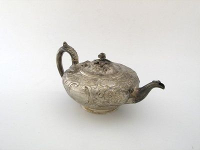 Appraisal: A Victorian squat teapot embossed with foliate decoration around the