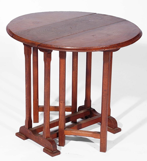 Appraisal: A Cotswold School walnut gateleg tablewith oval top on carved