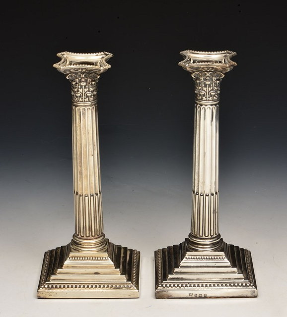 Appraisal: A PAIR OF SILVER CORINTHIAN COLUMN CANDLESTICKS with square cut