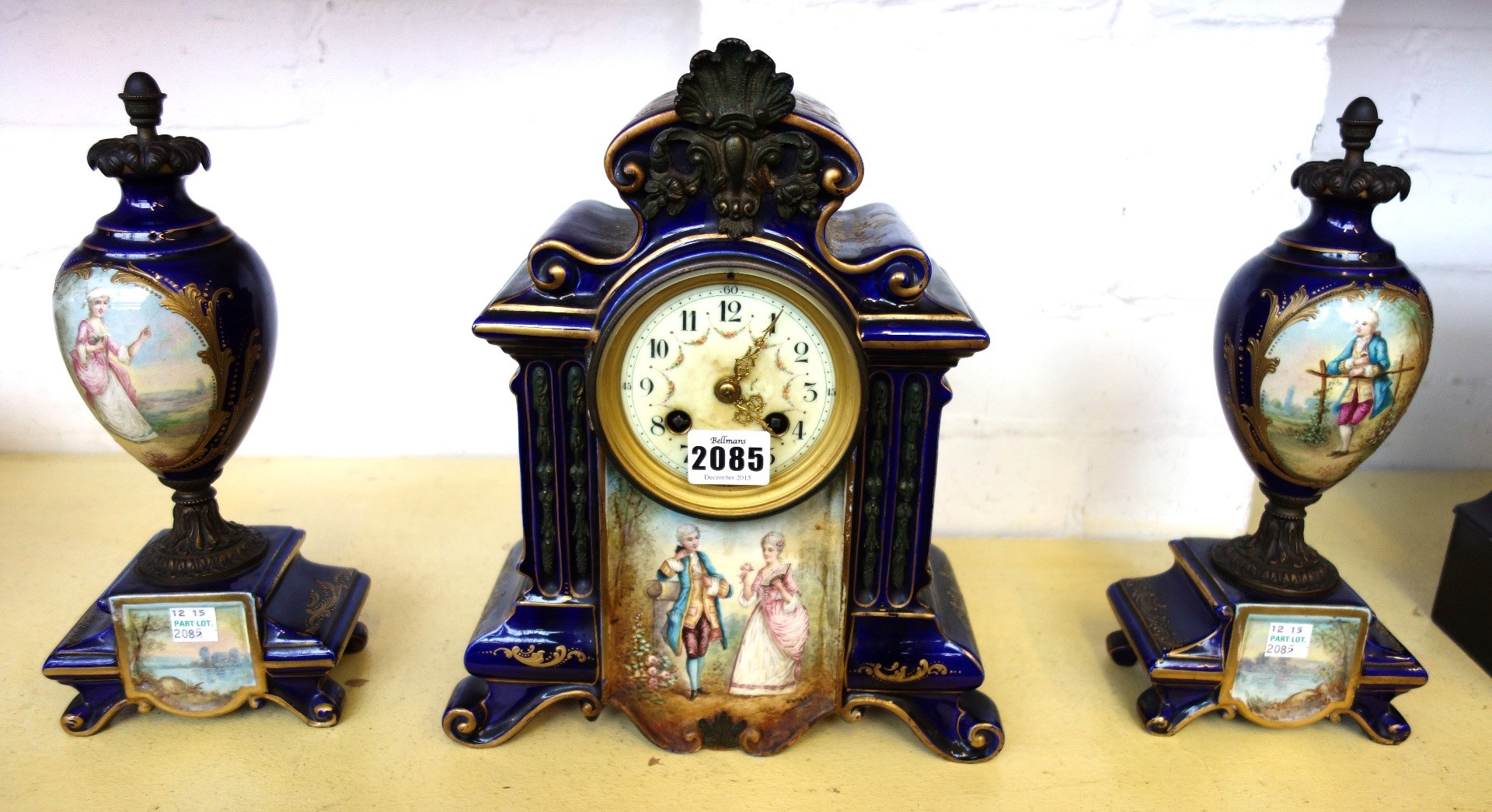 Appraisal: A three piece pottery blue glaze and painted clock garniture