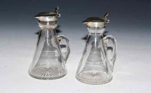 Appraisal: A PAIR OF SILVER MOUNTED WHISKY TOTS with scrolled handles