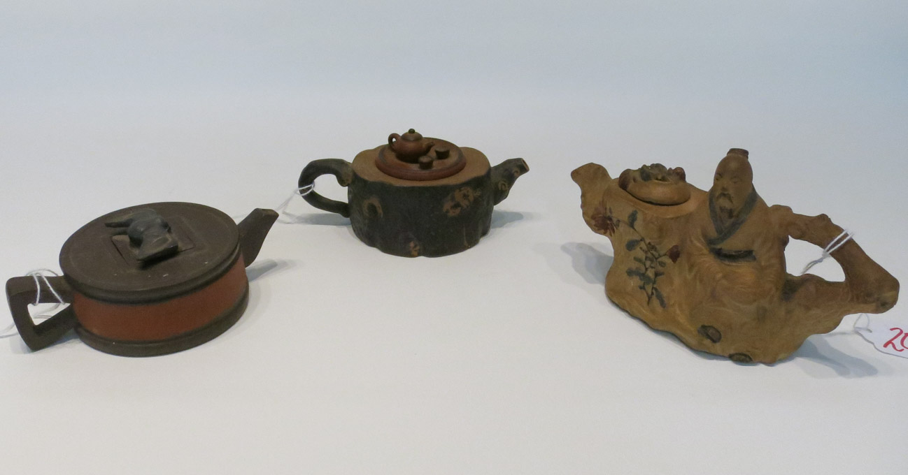 Appraisal: THREE CHINESE POTTERY FIGURAL TEAPOTS the first depicting a seated