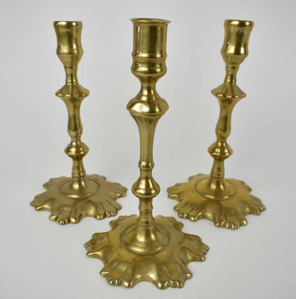 Appraisal: THREE GEORGIAN BRASS CANDLESTICKS th th Century Comprising a pair