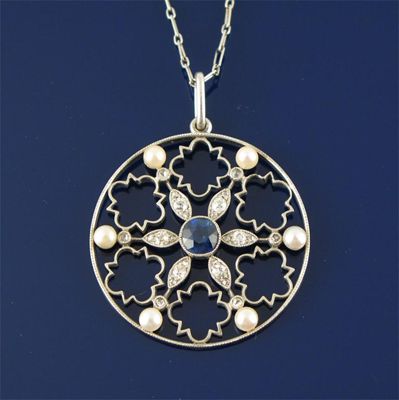 Appraisal: An Edwardian circular pendant Centred with a sapphire with diamonds