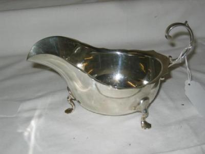 Appraisal: A SAUCE BOAT of bellied form with gimped rim flying