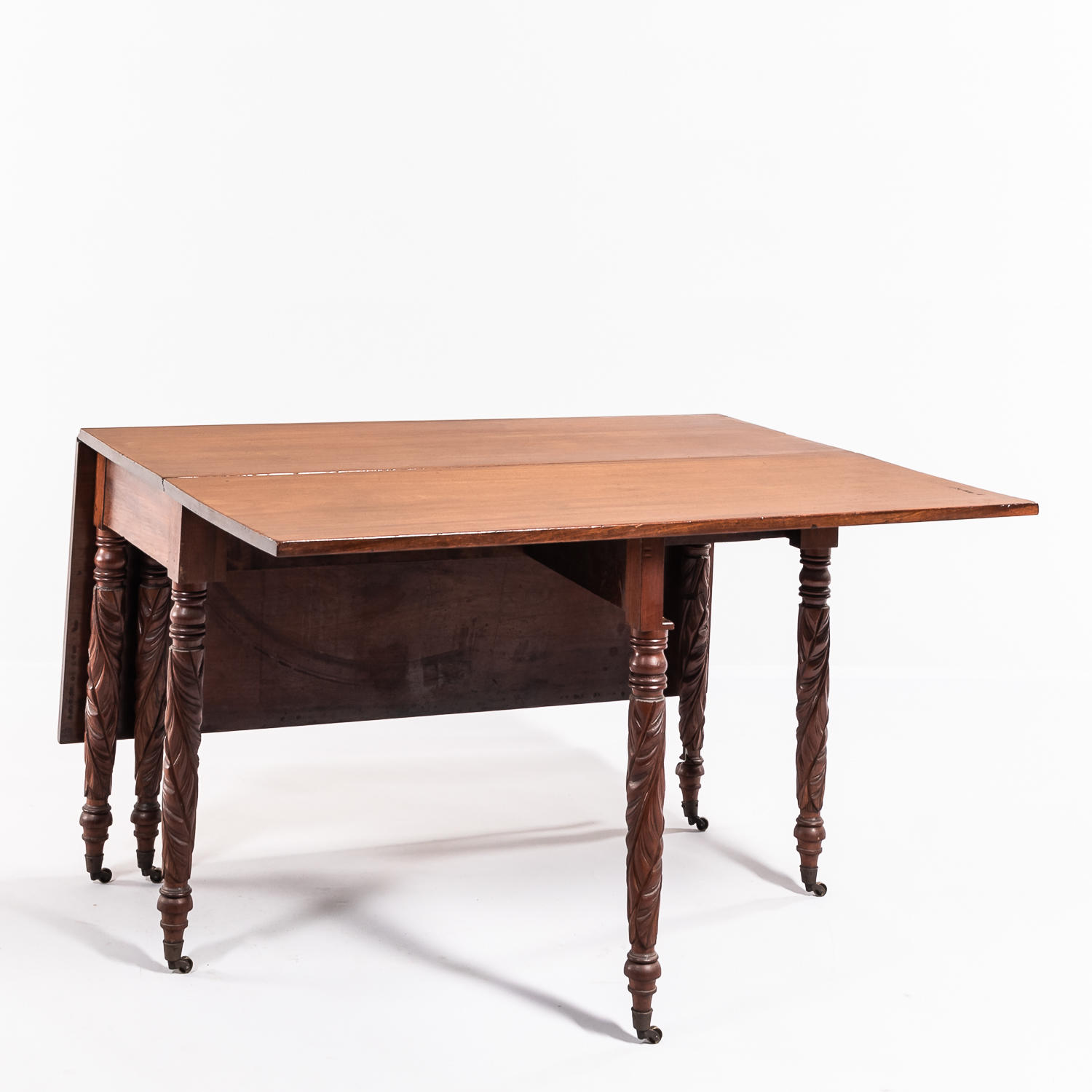 Appraisal: Neoclassical-style Mahogany Drop-leaf Table with carved foliate legs on casters