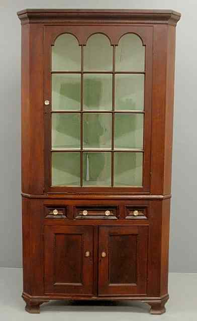 Appraisal: Pennsylvania cherry two-piece corner cupboard c with a molded cornice