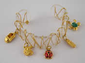 Appraisal: A perspex and yellow metal tests carat gold charm bracelet