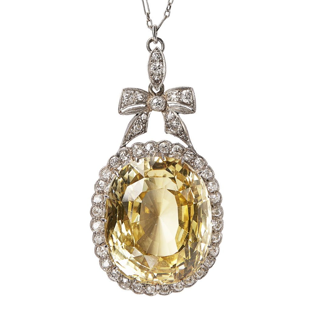 Appraisal: A yellow sapphire and diamond set cluster pendant claw set