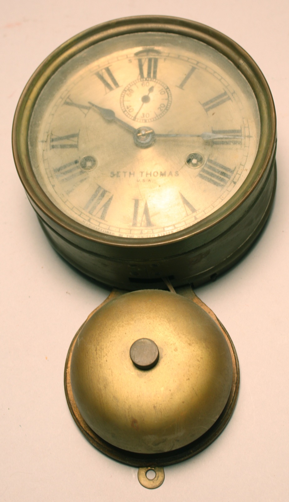 Appraisal: SETH THOMAS BRASS WALL-MOUNTED CLOCK WITH BELL Metal dial Most