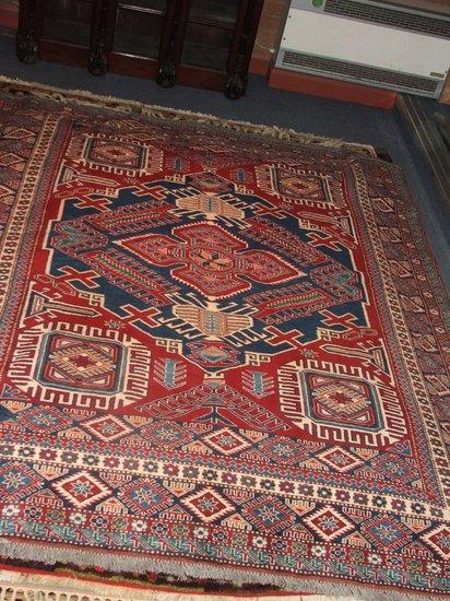 Appraisal: A MODERN TURKISH USAK RED GROUND WOOLLEN SMALL CARPET decorated