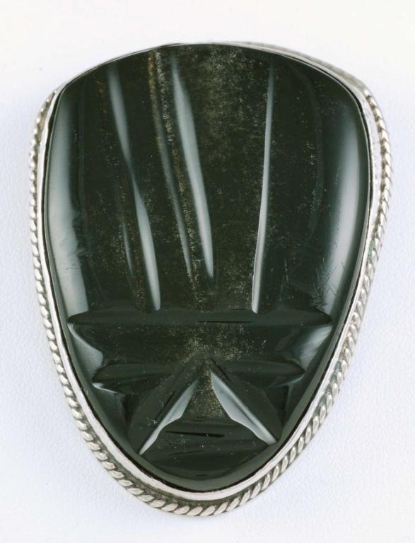 Appraisal: A carved gold sheen obsidian face inset into a sterling