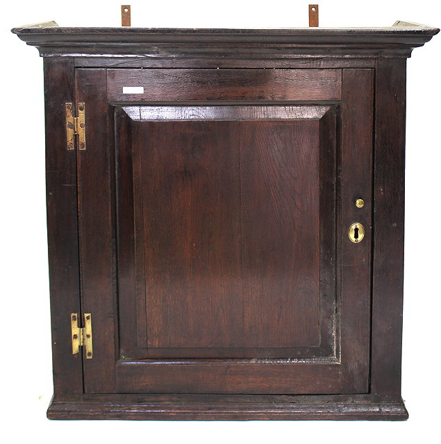 Appraisal: AN ANTIQUE OAK HANGING CUPBOARD with single panelled door enclosing