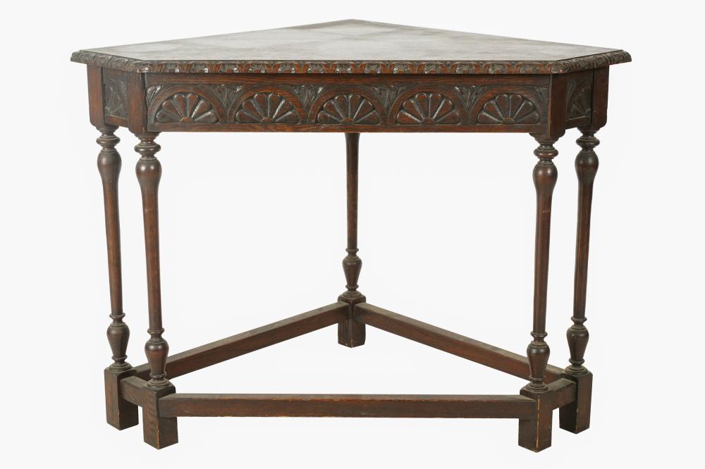 Appraisal: ENGLISH CARVED OAK CORNER TABLEthe triangular top with canted front