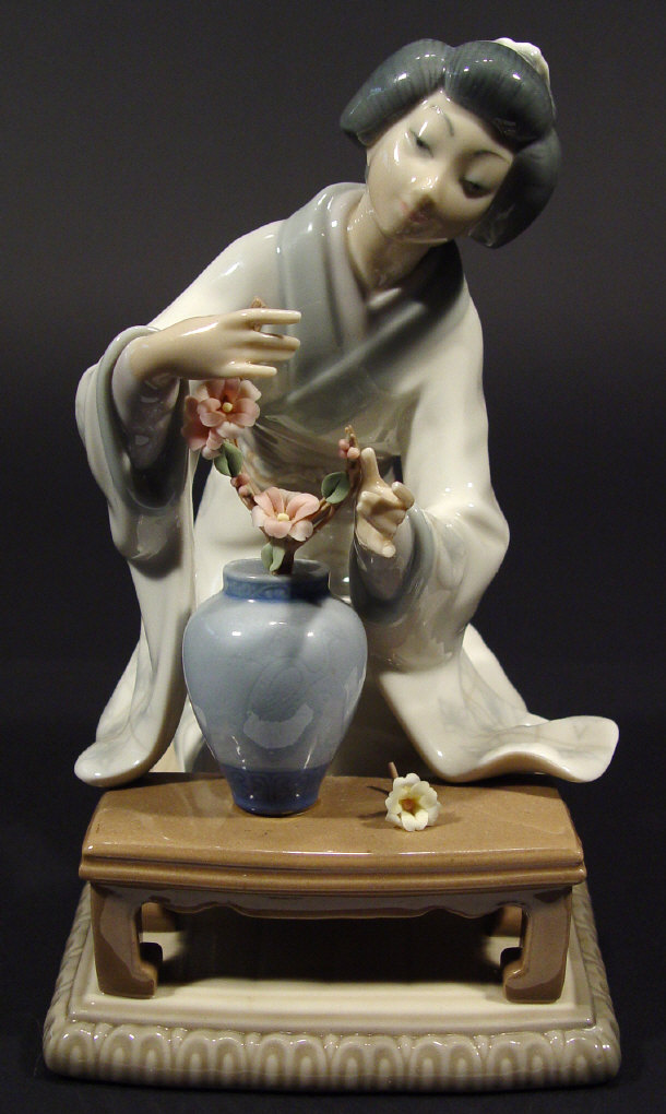 Appraisal: Lladro porcelain geisha girl arranging flowers at a table with