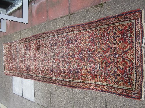 Appraisal: An Oriental runner with floral designs on a madder ground