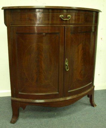 Appraisal: A floor standing mahogany corner cabinet a single drawer above