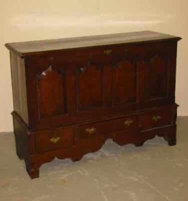 Appraisal: AN OAK COFFER with hinged plank lid the fascia with