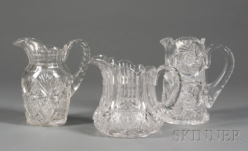 Appraisal: Three Cut Glass Water Pitchers th century varying shapes and