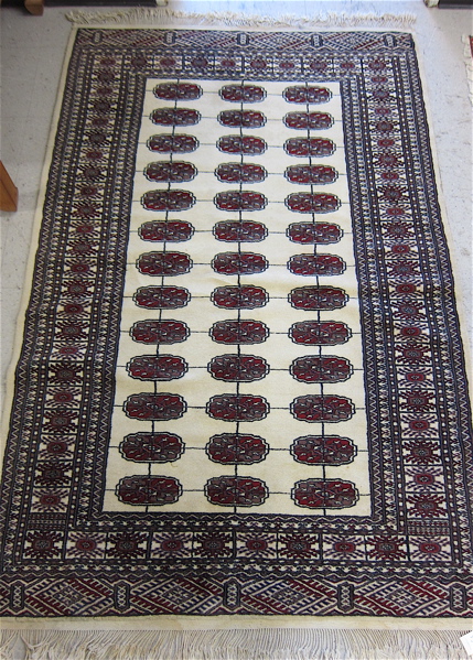 Appraisal: HAND KNOTTED BOKHARA AREA RUG featuring three columns of Turkoman