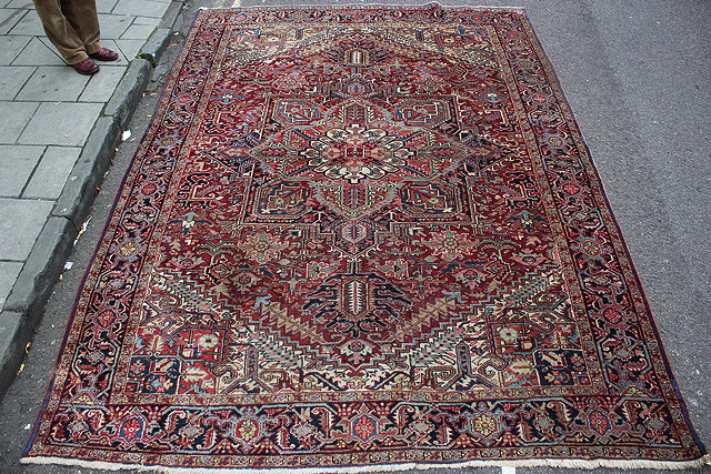 Appraisal: A HEREZ RED GROUND SMALL CARPET with a central stylised