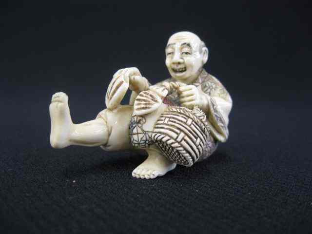 Appraisal: Carved Ivory Netsuke of a Seated Man holding a basket