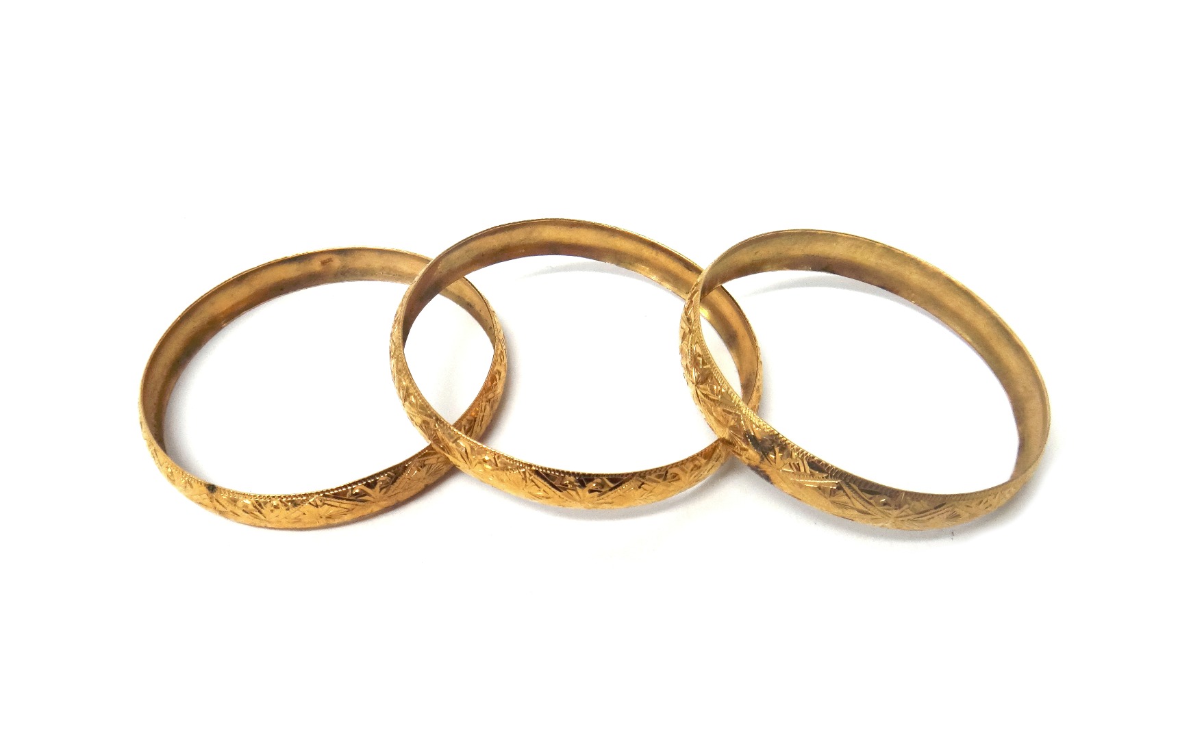 Appraisal: Three gold circular bangles each having engraved decoration and detailed