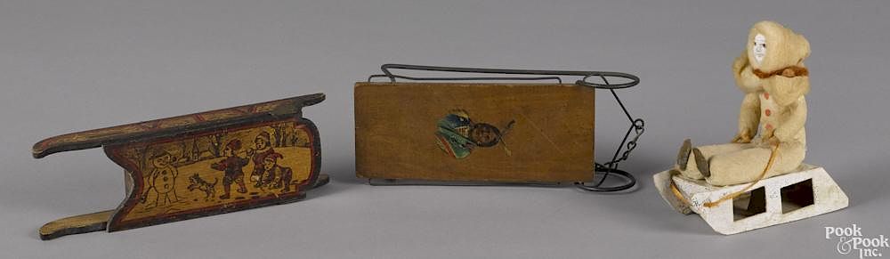 Appraisal: Three miniature wooden sleds one with a decal of a