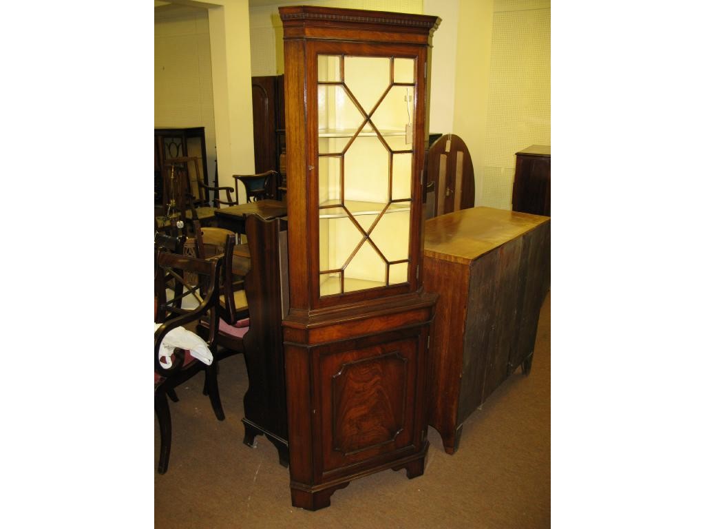 Appraisal: A reproduction mahogany corner cabinet with astragal glazed door and