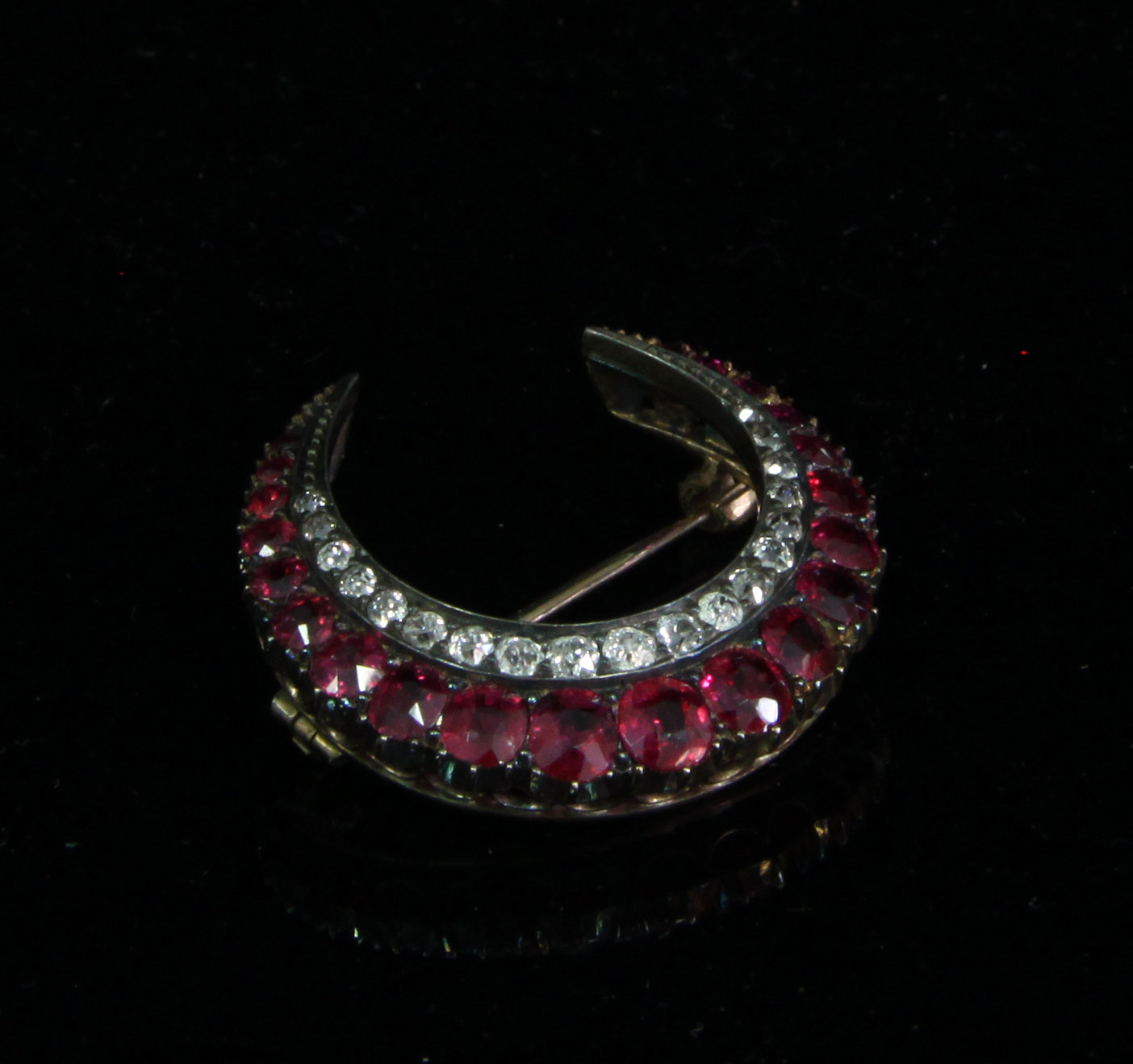 Appraisal: A ruby and diamond crescent brooch the two rows of