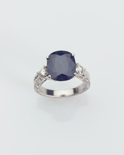 Appraisal: SAPPHIRE AND DIAMOND Three-stone ring in platinum Cushion-cut blue sapphire