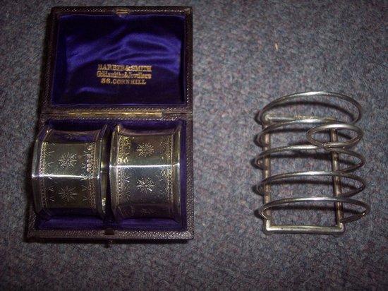 Appraisal: Two octagonal napkin rings and a five bar toast rack