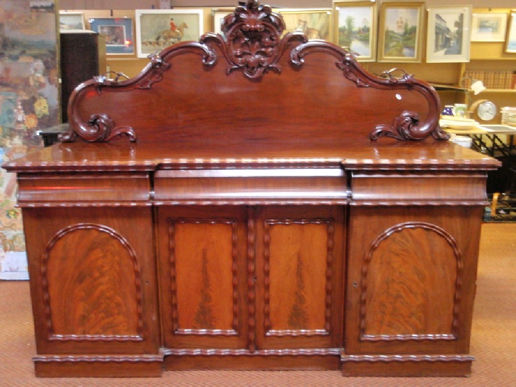 Appraisal: A Victorian figured mahogany sideboard the low arched back with