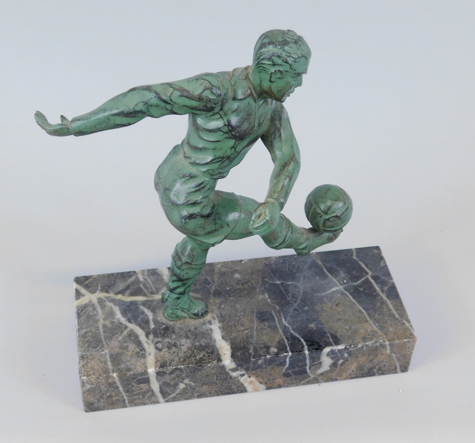 Appraisal: A bronzed spelter model of a footballer kicking a ball